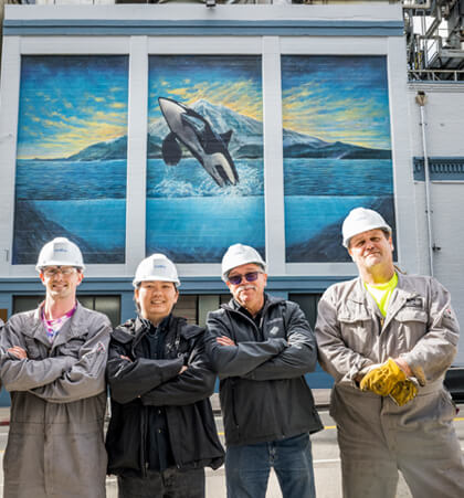 CenTrio Seattle Plant Operators posing outside the plant underneath our restored Orca Mural