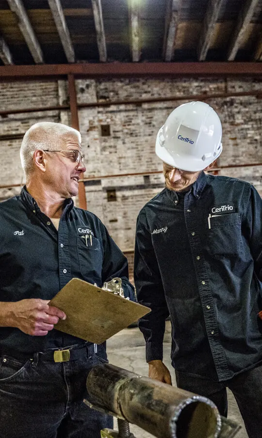 Photo of two CenTrio Operators working on a project and discussing next steps.