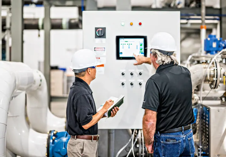 Two plant workers looking at a screen inside our CenTrio National Western Center plant.