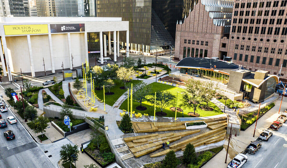 Open green space in the middle of downtown Houston, TX with several buildings in the background.