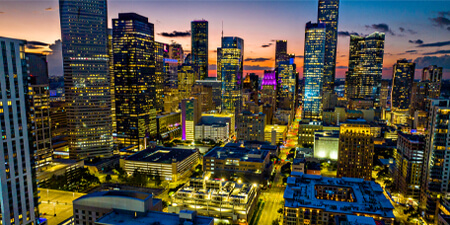 Downtown Houston, TX skyline late during sunset where all the building and city lights are noticeable.