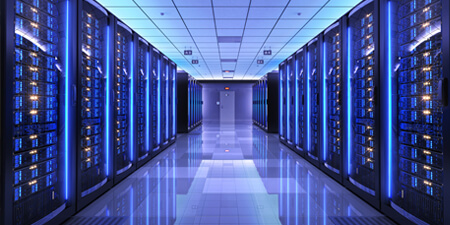 Inside a data center room with multiple large data servers on both side with an exit door in the back with a purple overlay.