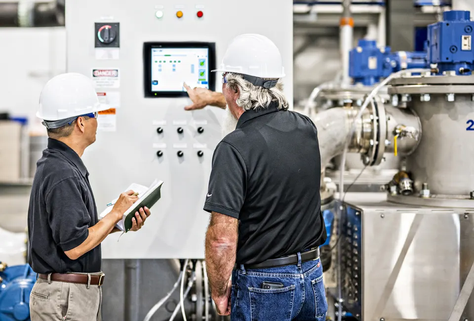 Two CenTrio operators in our National Western Center plant in Denver, CO looking at a screen and reviewing the status of the equipment.
