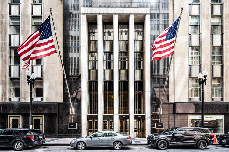 Photo showing the Infinite Chicago Building with the Chicago train speeding along on the high rail tracks.