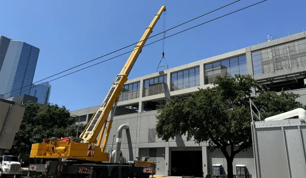 construction crane installing equipment at district energy facility in urban environment